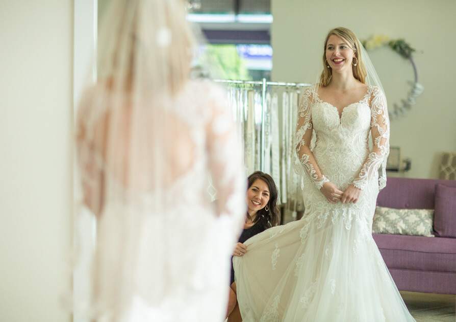 Bride standing in front of a mirror in a boutique
